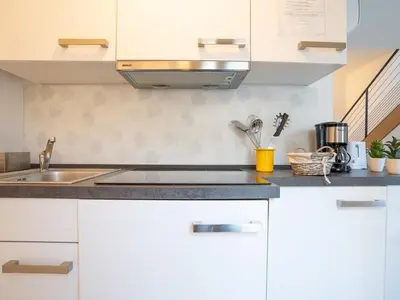 a kitchen with white cabinets and a sink at Apartment Wilson by Interhome in Nice