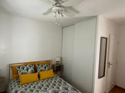a bedroom with a bed and a ceiling fan at Renoir Appartement in Cagnes-sur-Mer