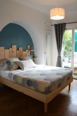 a bedroom with a large bed with a wooden headboard at 6 bedrooms seaview house, Old Town in Nice