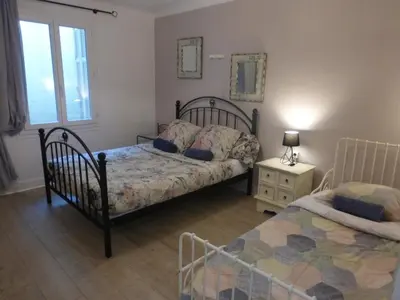 a bedroom with two beds and a table with a lamp at 6 bedrooms seaview house, Old Town in Nice