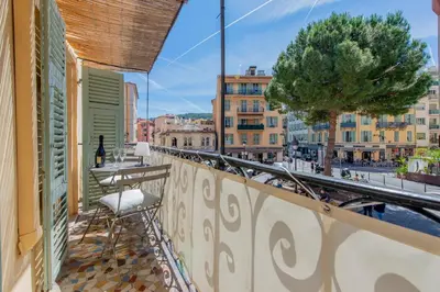 a balcony with a chair and a view of a city at Place Du Pin in Nice