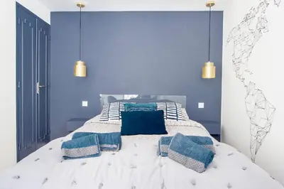 a bedroom with blue walls and a bed with blue pillows at Place Du Pin in Nice