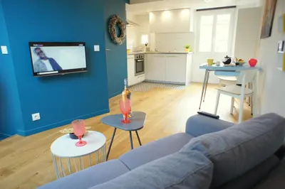 a living room with a couch and a tv on a blue wall at Ze Perfect Place - Superbe Studio Vieux Nice - calme et climatisé in Nice