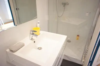 a white bathroom with a sink and a shower at Ze Perfect Place - Superbe Studio Vieux Nice - calme et climatisé in Nice