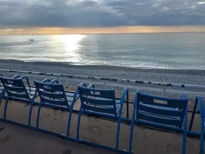 three blue chairs on a beach with the ocean at Palais Ophelia in Nice