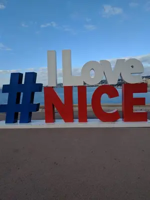 a sign that says love nirvana on the beach at Palais Ophelia in Nice