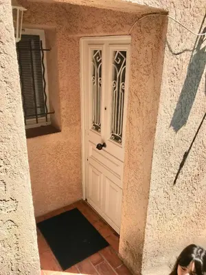 a white door in a building with a woman standing next to it at L'Alivu in Nice