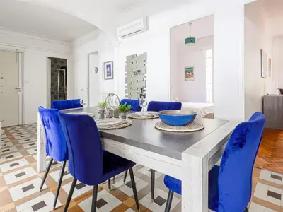 a dining room with a table and blue chairs at Apartment Le Rossi by Interhome in Nice
