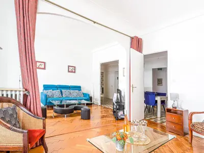 a living room with a blue couch and a table at Apartment Le Rossi by Interhome in Nice