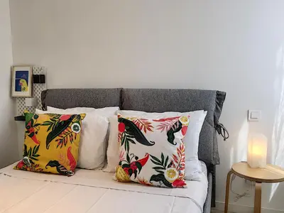 a bed with four pillows and a candle on it at Nestor&Jeeves - HOUSE OF CARDS - Central - Very close sea in Nice