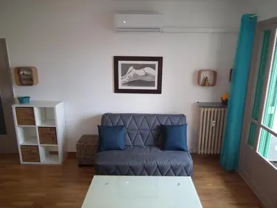 a living room with a couch and blue pillows at Nice Seaview Free Parking 4.Pers in Nice