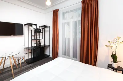 a bedroom with a bed and a table and a window at Arome Hôtel in Nice