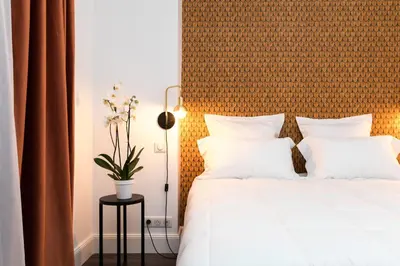 a bedroom with a bed with white pillows at Arome Hôtel in Nice