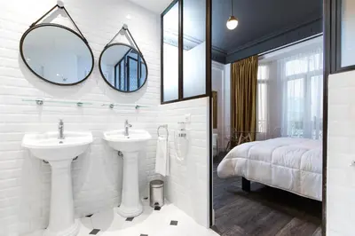 a bathroom with a sink and two mirrors at Arome Hôtel in Nice
