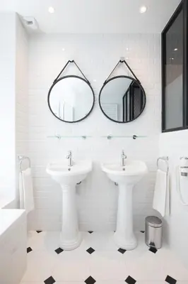 a white bathroom with two sinks and mirrors at Arome Hôtel in Nice