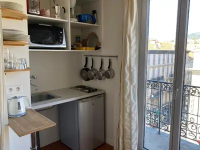 a kitchen with a counter and a balcony at Studios Floreal in Nice