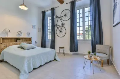 a bedroom with a bed and a bicycle hanging on the wall at MY CASA - GARIB - Place Garibaldi - 4 bedrooms - Balcony in Nice