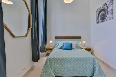 a bedroom with a bed with blue pillows at MY CASA - GARIB - Place Garibaldi - 4 bedrooms - Balcony in Nice