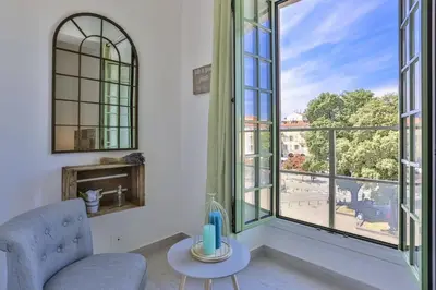 a living room with a chair and large windows at MY CASA - GARIB - Place Garibaldi - 4 bedrooms - Balcony in Nice