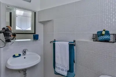 a white tiled bathroom with a sink and a mirror at MY CASA - GARIB - Place Garibaldi - 4 bedrooms - Balcony in Nice