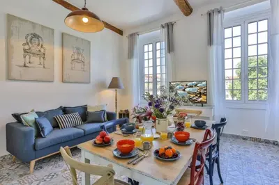 a living room with a table and a blue couch at MY CASA - GARIB - Place Garibaldi - 4 bedrooms - Balcony in Nice