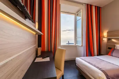 a hotel room with a couch and a window at Hotel Le Saint Paul in Nice