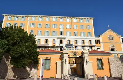 a large yellow building with a clock tower on it at Hotel Le Saint Paul in Nice