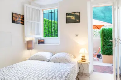 a white bedroom with a bed and a window at Place du Pin in Nice
