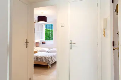 a bedroom with a bed and a door leading into a room at Place du Pin in Nice