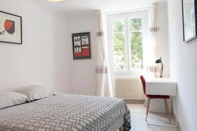 a bedroom with a bed and a desk and a window at Place du Pin in Nice