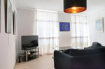 a living room with a couch and a television at Place du Pin in Nice