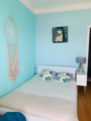 a blue bedroom with a white bed with two pillows at Villa Iris in Nice