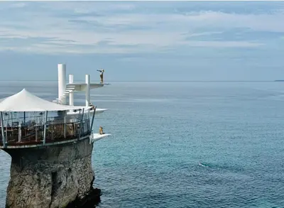 a lighthouse on a cliff in the water at Villa Iris in Nice