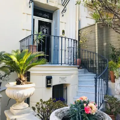 a house with a staircase and a vase with flowers at Villa Saint Hubert in Nice