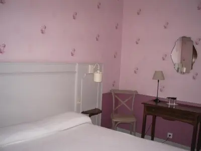 a bedroom with a bed and a table and a mirror at Villa Saint Hubert in Nice