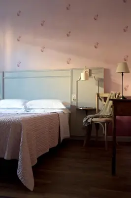 a bedroom with a bed and a table and a chair at Villa Saint Hubert in Nice