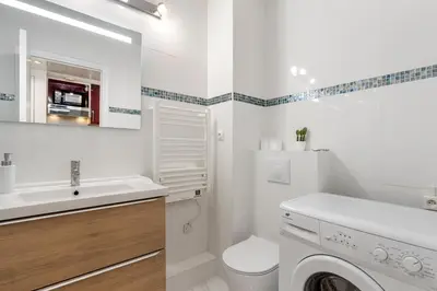 a white bathroom with a sink and a washing machine at Studio Massenet Five stars holiday house in Nice