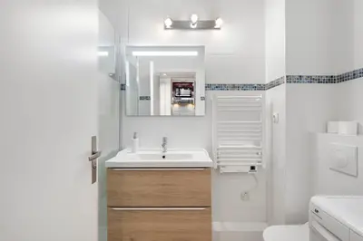 a white bathroom with a sink and a mirror at Studio Massenet Five stars holiday house in Nice
