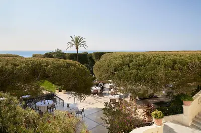 a yellow house with a swimming pool in front of it at Grand-Hôtel du Cap-Ferrat, A Four Seasons Hotel in Saint-Jean-Cap-Ferrat