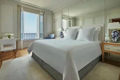a bedroom with a large window with a view of the ocean at Grand-Hôtel du Cap-Ferrat, A Four Seasons Hotel in Saint-Jean-Cap-Ferrat