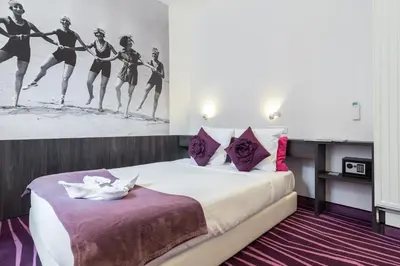 a hotel room with a bed with a painting of women dancing at Nice Appart in Nice