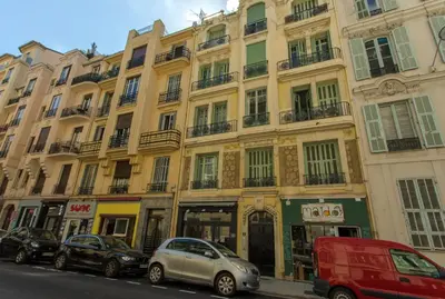 a large building with cars parked in front of it at Nice Central Art Deco Flat 45 m² in Nice
