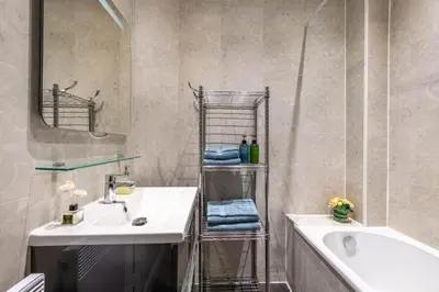 a bathroom with a sink and a tub and a mirror at Nice Central Art Deco Flat 45 m² in Nice
