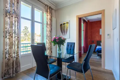 a dining room with a glass table and blue chairs at VICTOR HUGO - Modern and sunny, terrace, 2 baths in Nice