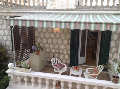 a balcony with chairs and a awning on a building at Appartement Tout Confort avec Terrasse in Nice