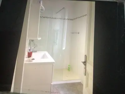 a white bathroom with a shower and a sink at Appartement Tout Confort avec Terrasse in Nice
