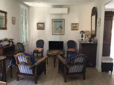 a living room with chairs and a table and a fireplace at Appartement Tout Confort avec Terrasse in Nice