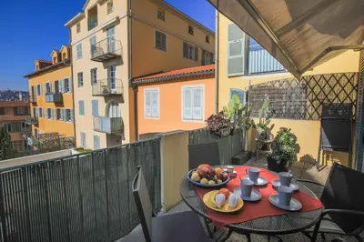 a table with a bowl of fruit on a balcony at La Providence Nice in Nice