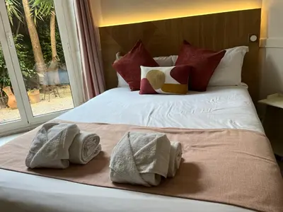 a hotel room with two beds and a mirror at Nice Garden Hotel in Nice