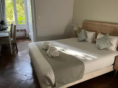 a bedroom with a bed and a table and a mirror at Nice Garden Hotel in Nice